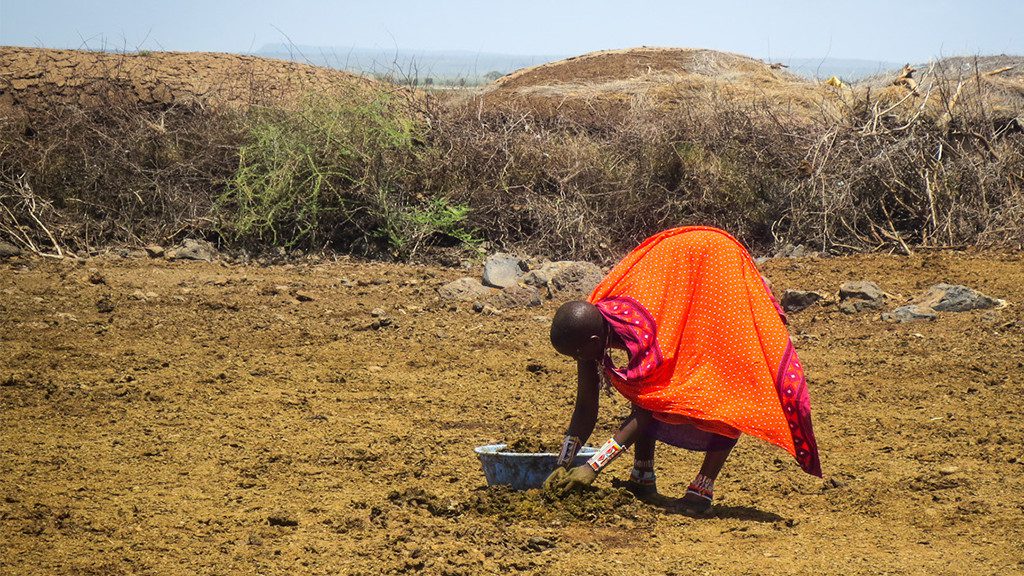 kenyan woman beginning to prepare hut